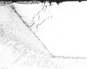 Figura 1 - Seção transversal de solda mostrando a localização da corrosão na margem do fino passe de solda de raiz. 24x 